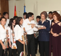 El director de la Orquesta de Instrumentos Reciclados de Cateura, Fabio Chávez, hace entrega a Doña Sofía de un violín hecho con materiales reciclados